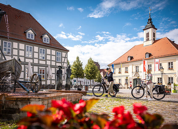 Radtouristinnen in kleiner Stadt in Brandenburg Zwei Frauen mit Fahrrädern auf einem kleinen Marktplatz in einer brandenburgischen kleinen Stadt