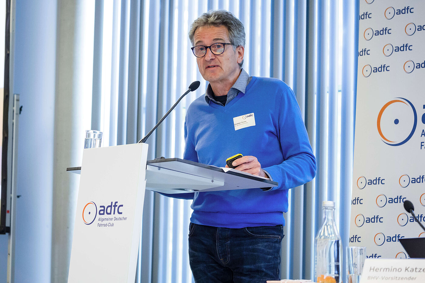 Christian Tänzler ADFC-Bundesvorstand Christian Tänzler steht auf der Bühne und spricht ins Mikrofon.